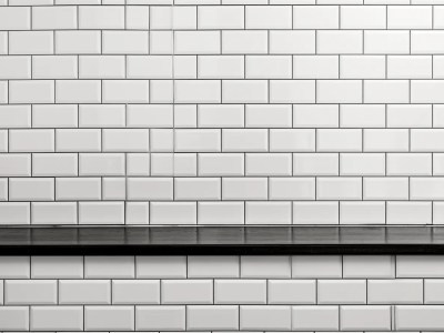 Black And White Photo Of A Tile Wall With Black Ledge