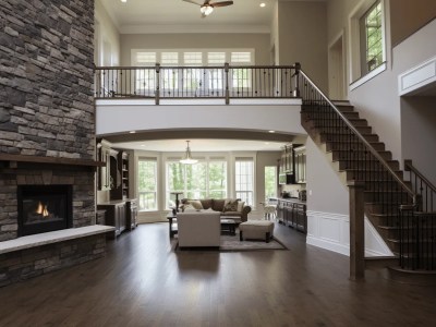 Open Living Room Area With Stairway Leading To A Stone Fireplace