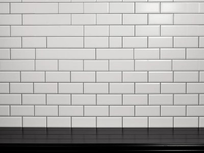 White Tile Wall With A Black Table Photo